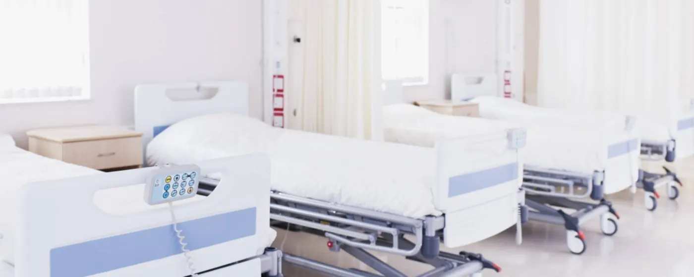 A row of hospital beds in a medical room ready for patients during Sick Visits.