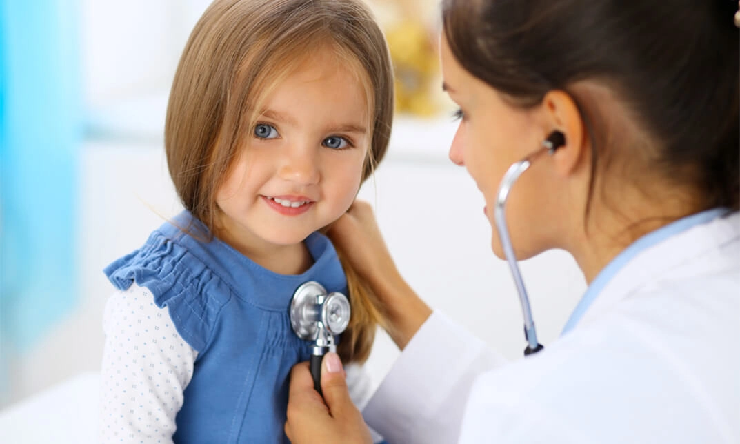 Doctor checking a young new patient with a stethoscope during a medical exam