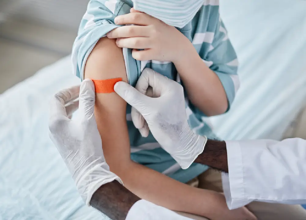 Young boy getting vaccinated by a healthcare professional in a clinic setting