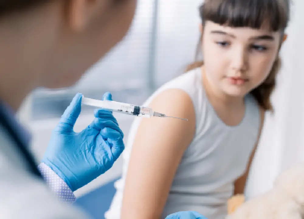 Doctor examining young child during routine visit Back to School Immunizations.