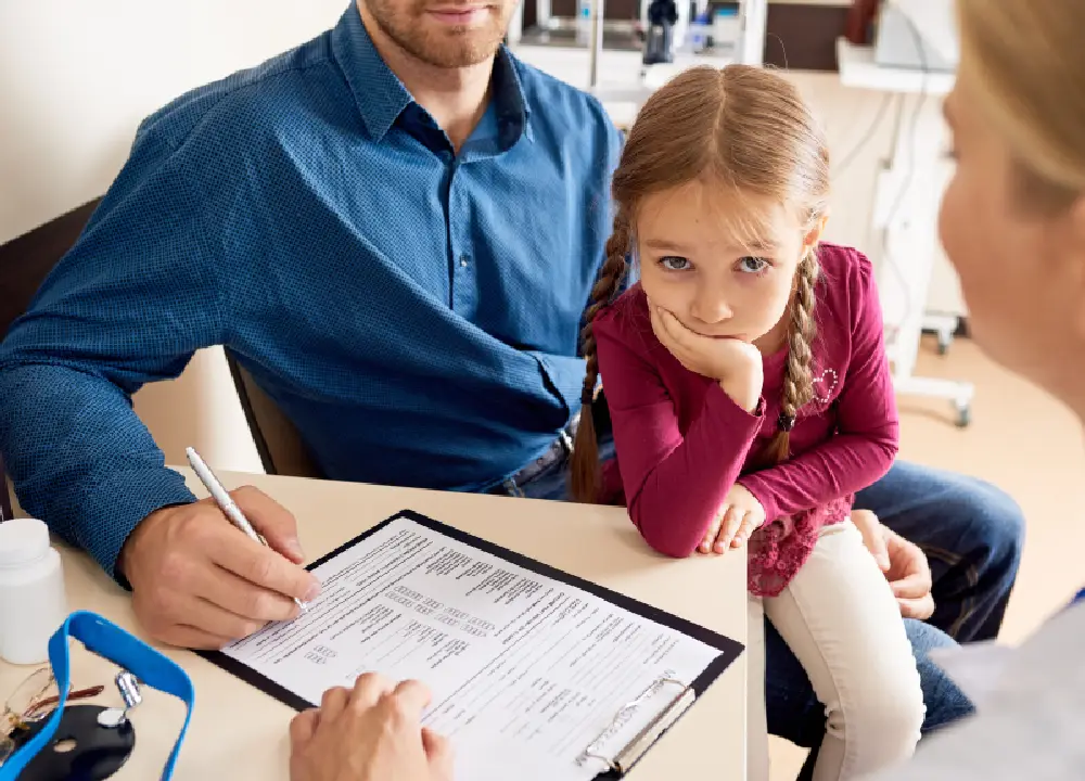 Parent holding a child’s vaccination record at a pediatric clinic in Katy, TX, preparing for a childhood immunization appointment”